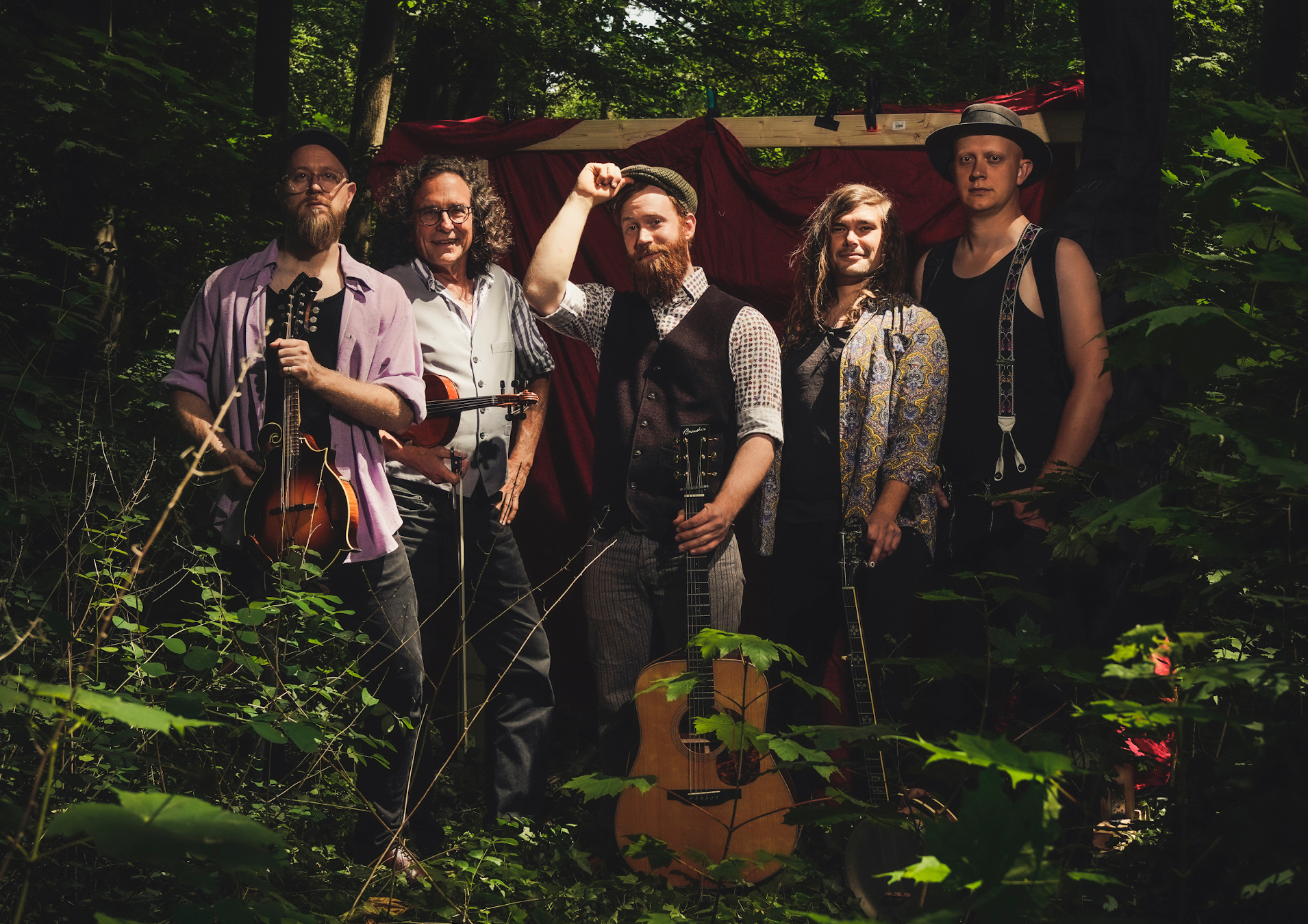 Bashed Potatoes in a forest, holding a guitar and a mandoline